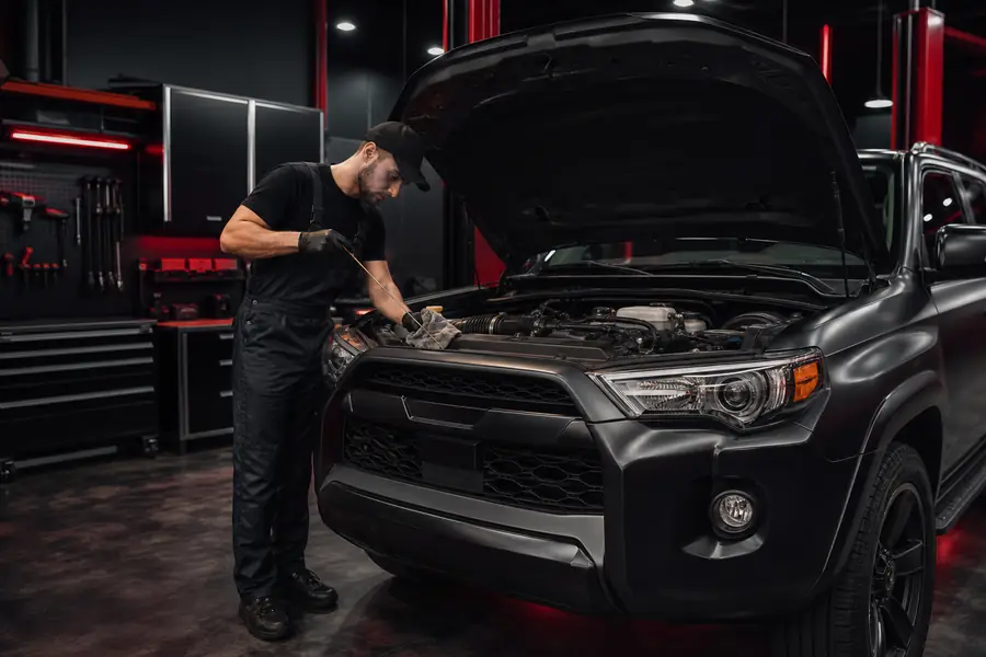 Technician checking tire pressure and fluids on an SUV at a Canton Michigan service center